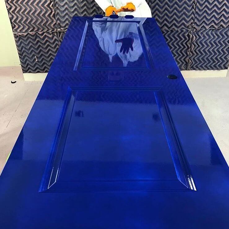 photo of blue high gloss paint on door with person showing the reflection.